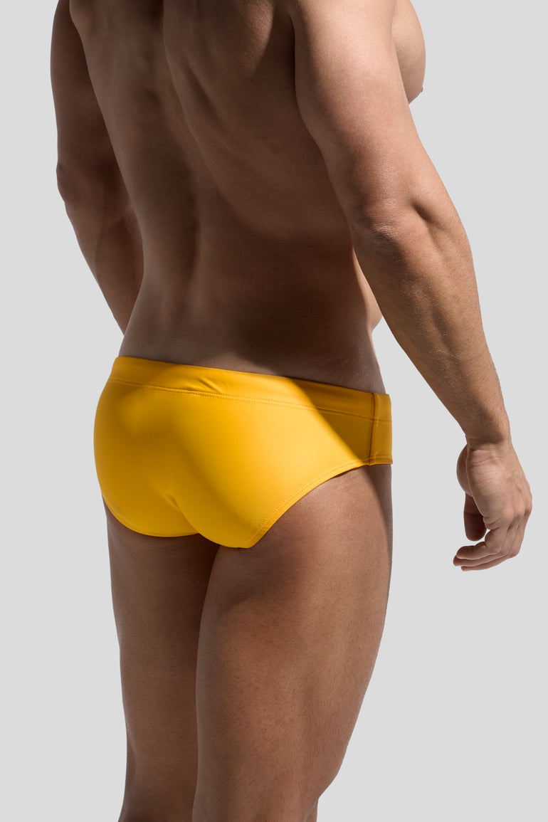 image of swimwear slip in Madarin yellow back view on male model by Bas Bains