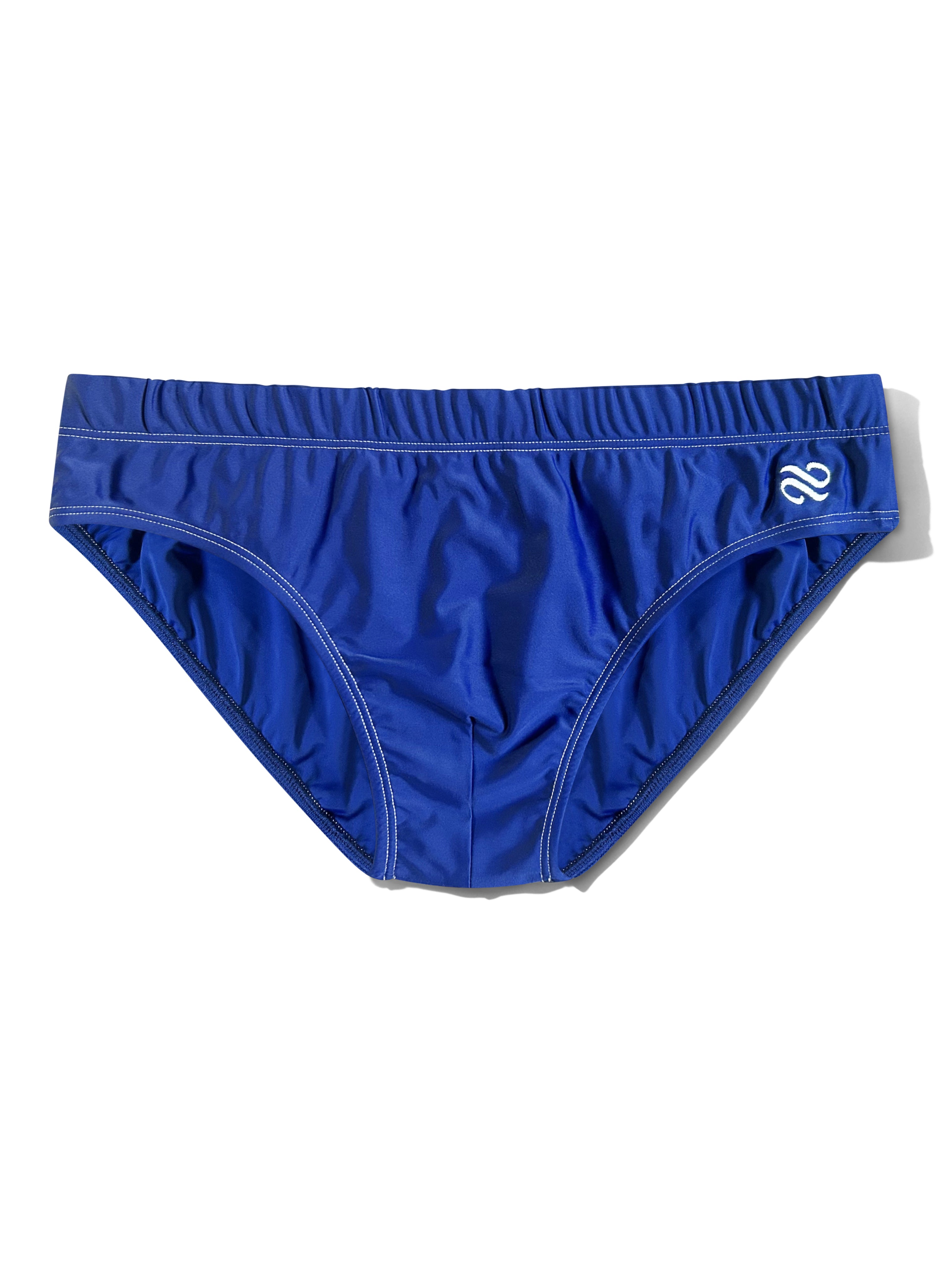 A pair of royal blue swim briefs with a white stylized logo on the right hip, displayed flat against a white background.