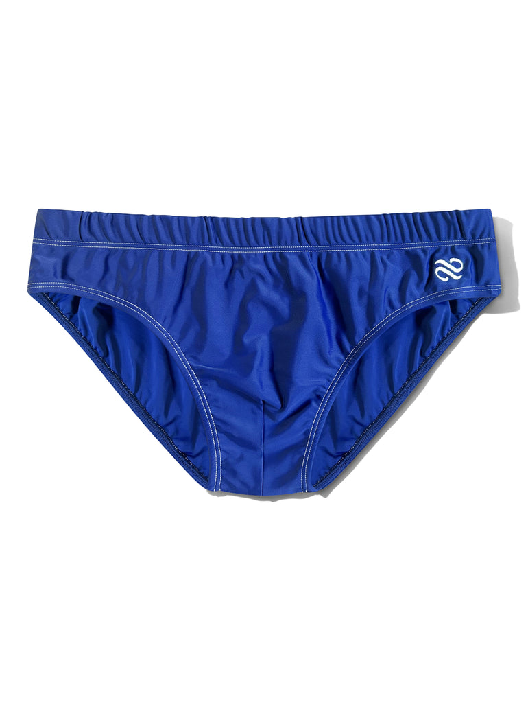 A pair of royal blue swim briefs with a white stylized logo on the right hip, displayed flat against a white background.