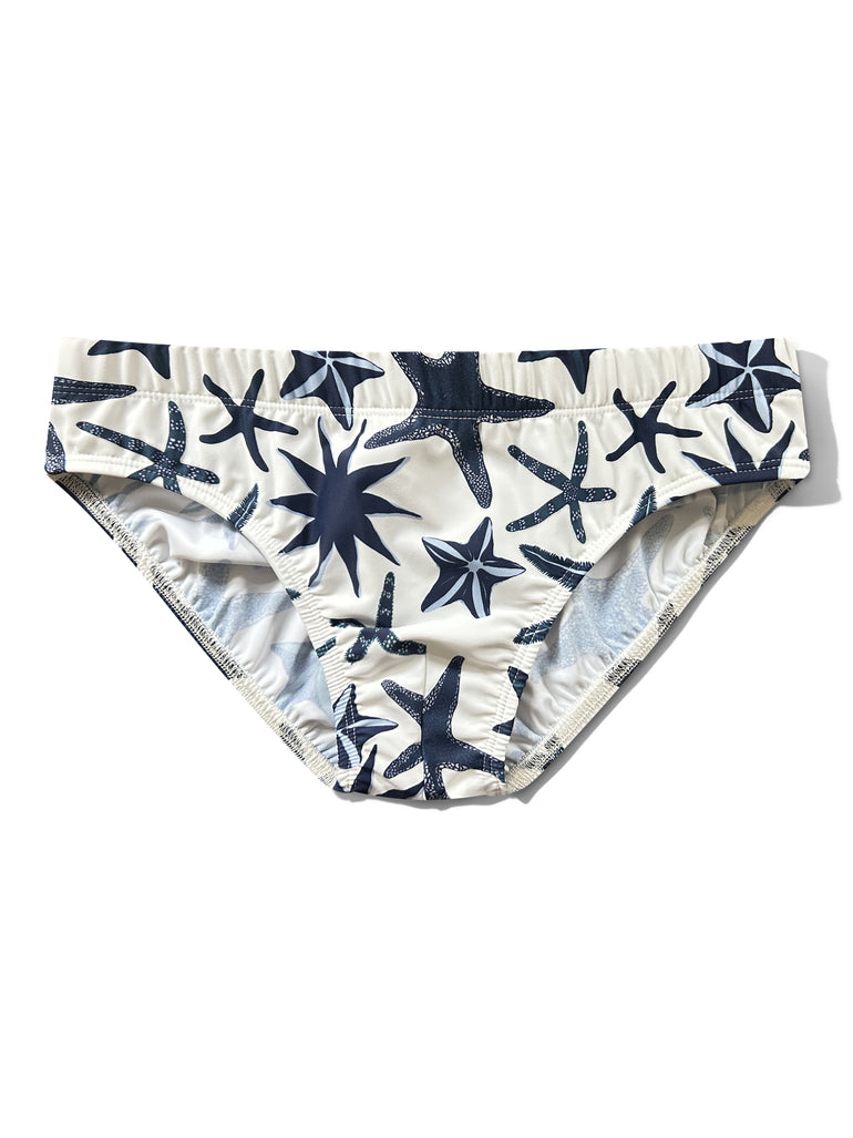 White men's swim slip featuring a navy blue starfish pattern, displayed flat against a white background.