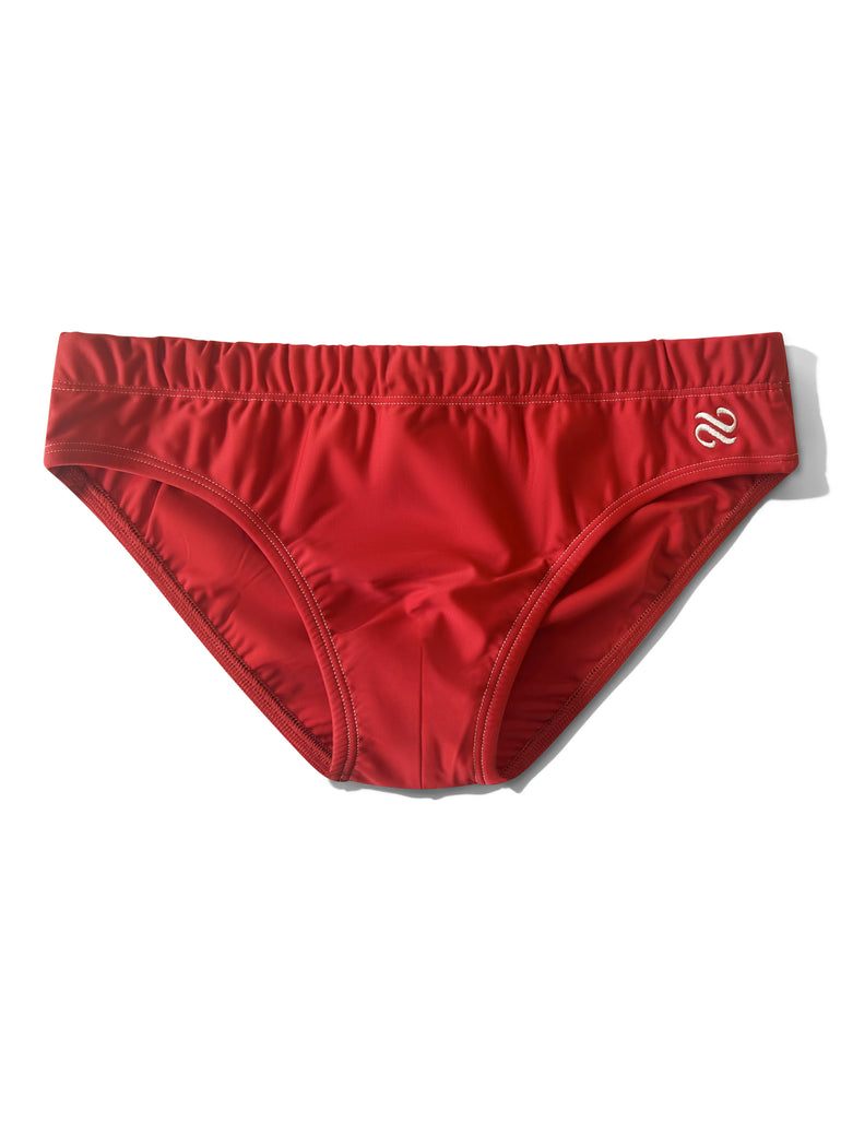 Red swim brief on a white background by Bas Bains