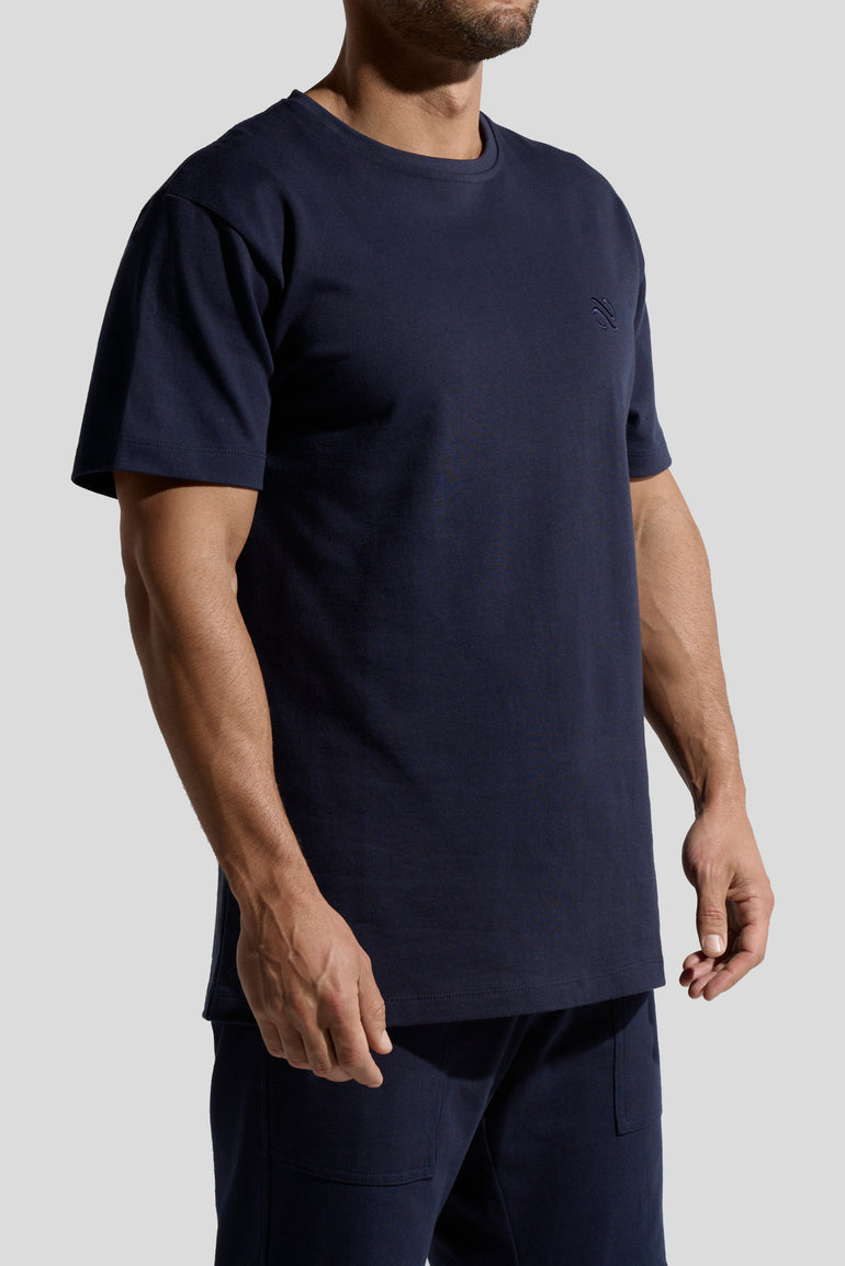 image of organic cotton T-shirt in Marino Blue side view on male model by Bas Bains