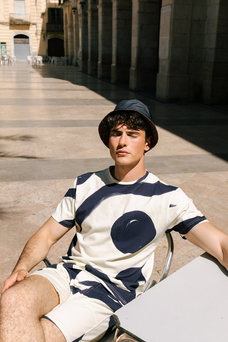 Dani Garcia in on a terrace in Vilanova wearing Rivage print Deia short and Faro T-shirt by Bas Bains